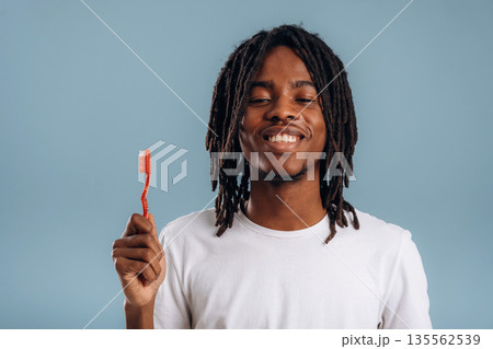 Brush your teeth. Black man is in the studio against soft background Brush your teeth. Black man is in the studio against soft background 135562539