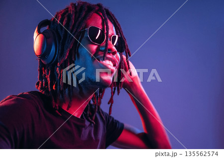 African American guy is studio with neon lighting 135562574