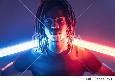 Neon lighting equipment. African American guy is studio Neon lighting equipment. African American guy is studio 135562604