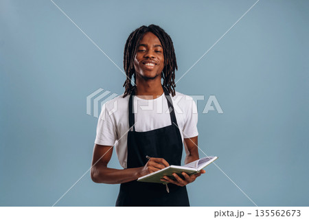 Standing, barista is in apron. Black man is in the studio against soft background 135562673