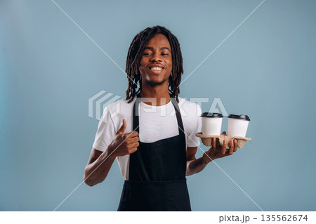 Barista is with coffee. Black man is in the studio against soft background 135562674