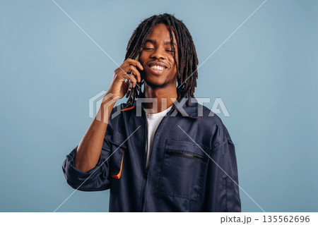 Talking by phone. Black man is in the studio against soft background 135562696