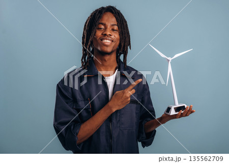 Wind turbine model in hand. Black man is in the studio against soft background 135562709