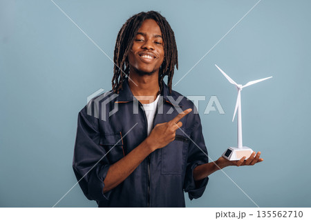 Wind turbine model in hand. Black man is in the studio against soft background 135562710