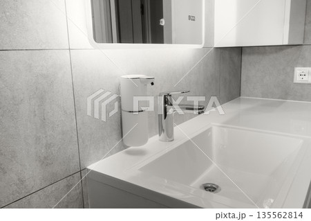 Modern bathroom setup in a minimalist interior, faucet and automatic, touchless soap dispenser. New 2026 trend Cloud Dancer color. Modern bathroom setup in a minimalist interior, faucet and automatic, touchless soap dispenser. New 2026 trend Cloud Dancer color. 135562814