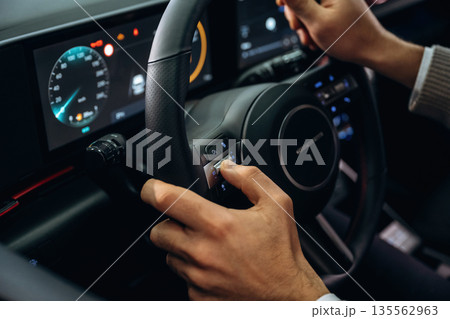 Driving, holding steering wheel. Man is sitting in car, detailed view Driving, holding steering wheel. Man is sitting in car, detailed view 135562963