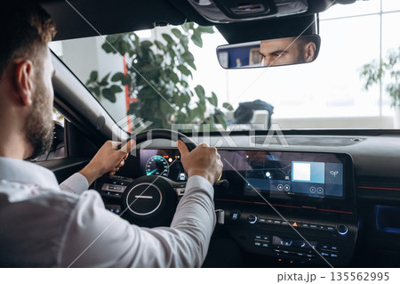 View from behind. Man is sitting in car, detailed view 135562995