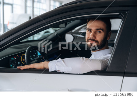 Man is with the car in dealership 135562996