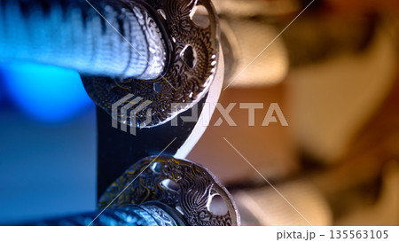 Detailed view of a traditional samurai sword guard with dragon motif and cinematic lighting Detailed view of a traditional samurai sword guard with dragon motif and cinematic lighting 135563105