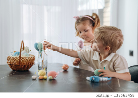 Colorful eggs for Easter. Kids are preparing bakery at home Colorful eggs for Easter. Kids are preparing bakery at home 135563459