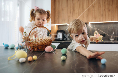 Holidays, colorful eggs for Easter. Kids are preparing bakery at home 135563467