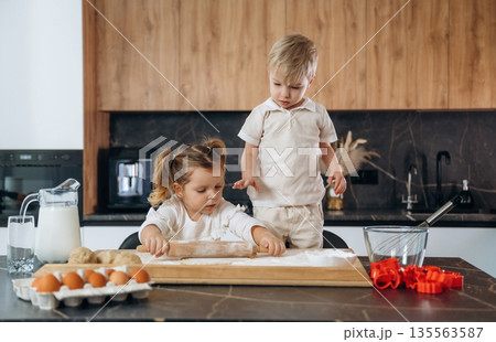 Sister and brother. Kids are preparing bakery at home Sister and brother. Kids are preparing bakery at home 135563587