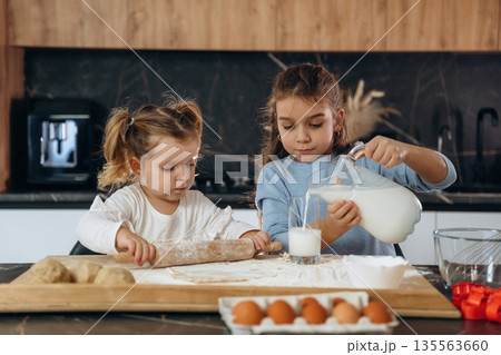 Sweet product. Two little girls are preparing bakery at home 135563660