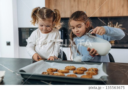 Finished cookies. Two little girls are preparing bakery at home 135563675