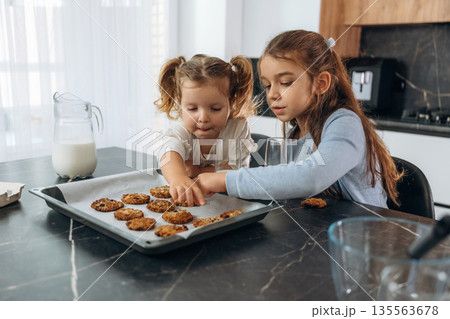 Finished cookies. Two little girls are preparing bakery at home 135563678
