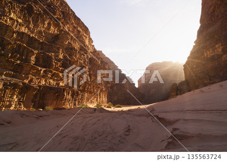 Sunrise light reveals rocky canyon with soft sand at the base in the desert. Wadi Rum desert, Jordan 135563724