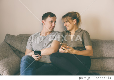 Man and woman holding smartphones Man and woman holding smartphones 135563813