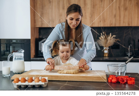 Bunch of eggs. Mother and daughter are cooking on the kitchen Bunch of eggs. Mother and daughter are cooking on the kitchen 135564278
