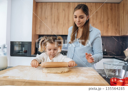 Two people. Mother and daughter are cooking on the kitchen Two people. Mother and daughter are cooking on the kitchen 135564285