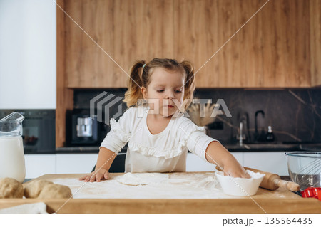 Little girl is preparing bakery at home Little girl is preparing bakery at home 135564435