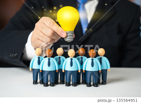 A lightbulb of an idea shines over a team of office workers. A leader inspires his subordinates. A project manager. Creative leadership concept, motivation and vision. Innovation culture 135564951