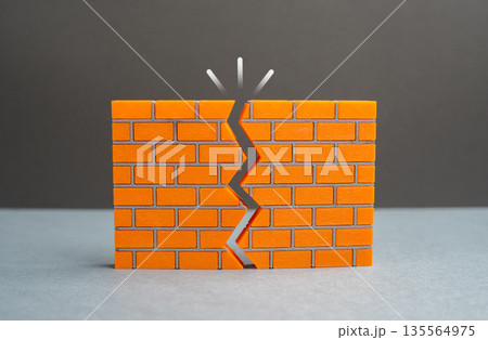 A crack in the wall. Issues with reliability. Lack of confidence in strength and resilience. Structural risk metaphor, hidden flaws and warning signs affecting safety 135564975