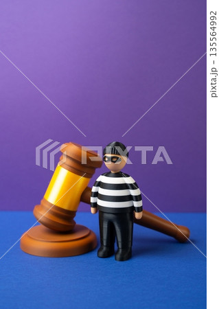 The criminal and the judge's gavel. The court sides with the criminal. Injustice and judicial mishaps. Wrong verdict concept, system failure, public outrage and erosion of trust in courts. 135564992