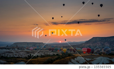 Hot air balloon flying over rocky landscape at sunrise in Cappadocia. Turkey 135565505