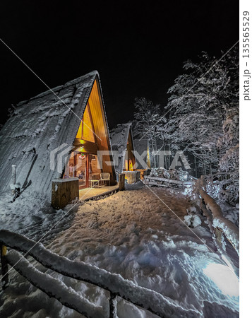 Three A Frame Cabins with Lights in Winter Forest Three A Frame Cabins with Lights in Winter Forest 135565529
