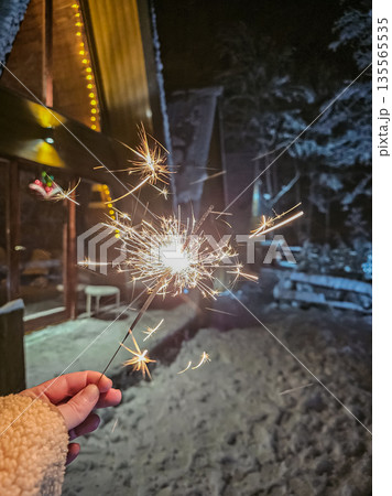 Hand Holding Sparkler Burning at Night 135565535
