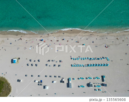 Beach vacation at sea in summer. Sea relax under beach umbrella. Travel to sea. Aerial view of sand beach with turquoise water. Luxury resort. Enjoying beach sun. Summer vacation. Exotic lifestyle Beach vacation at sea in summer. Sea relax under beach umbrella. Travel to sea. Aerial view of sand beach with turquoise water. Luxury resort. Enjoying beach sun. Summer vacation. Exotic lifestyle 135565608