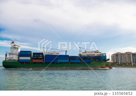 Container ship. Cargo ship with container. Freight container loaded on cargo vessel. View of cargo ship vessel navigating the sea leaving or entering harbor. Cargo business 135565652