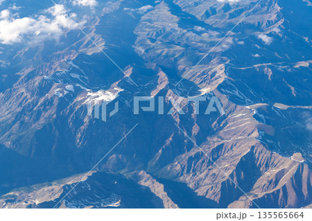 Landscape from plane. Top of mountain in cloud. Landscape with mountain in cloudy nature. Cloud and mountain peak aerial view. Aerial view of mountain landscape. Aerial cloudy view. Adventure 135565664