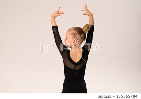 Smiling child in black ballroom outfit practicing elegant movement with hearing technology cochlear implant. Strength, inclusion, and artistic discipline harmonize to celebrate diversity and human 135565794