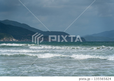 Blue sea with waves on rocks and hills Blue sea with waves on rocks and hills 135565824