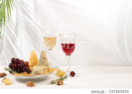 Still life with fine blue cheese, parmesan, grapes, honey, nuts, rosemary and wine. A cheese platter with seasonal wine appetizers, an Italian cuisine concept, and a restaurant and cafe menu 135565839