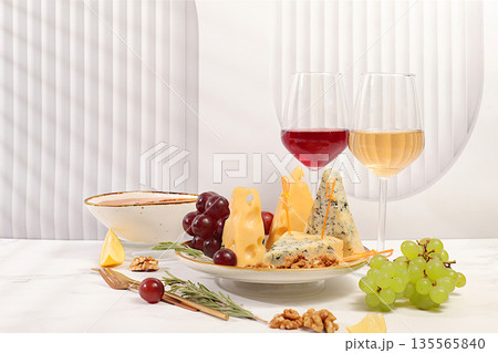 Still life with fine blue cheese, parmesan, grapes, honey, nuts, rosemary and wine. A cheese platter with seasonal wine appetizers, an Italian cuisine concept, and a restaurant and cafe menu 135565840