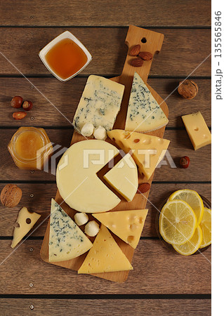 Still life with gourmet blue cheese, parmesan, grapes, honey, nuts, rosemary, lemon and walnuts. A cheese platter with seasonal wine appetizers, an Italian cuisine concept, and a restaurant menu. 135565846