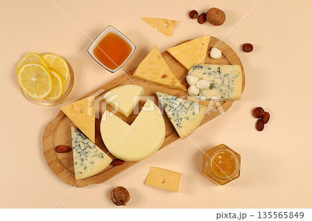 Still life with gourmet blue cheese, parmesan, grapes, honey, nuts, rosemary, lemon and walnuts. A cheese platter with seasonal wine appetizers, an Italian cuisine concept, and a restaurant menu. 135565849
