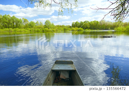 Countryside boat at river during spring flood. Spring landscape with flood Countryside boat at river during spring flood. Spring landscape with flood 135566472