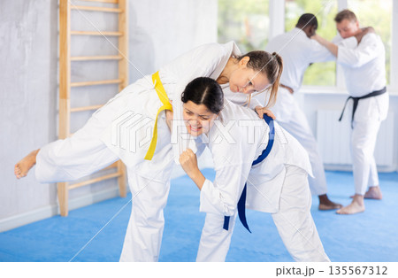 Female athletes playing Judo in sport hall Female athletes playing Judo in sport hall 135567312