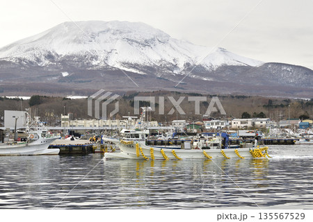 冬の北海道森町砂原漁港を出漁する漁船と雪の砂原岳の風景を撮影 冬の北海道森町砂原漁港を出漁する漁船と雪の砂原岳の風景を撮影 135567529