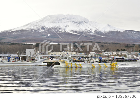 冬の北海道森町砂原漁港を出漁する漁船と雪の砂原岳の風景を撮影 冬の北海道森町砂原漁港を出漁する漁船と雪の砂原岳の風景を撮影 135567530