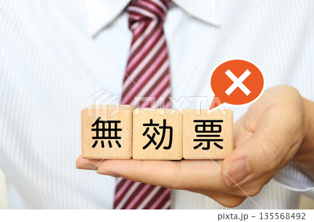 無効票を示す木製ブロックを持つ男性の手元。 無効票を示す木製ブロックを持つ男性の手元。 135568492