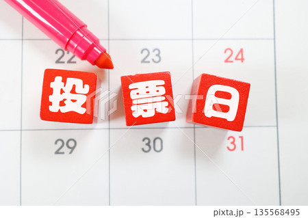 投票日を示す赤い木製ブロックとカレンダー背景。 投票日を示す赤い木製ブロックとカレンダー背景。 135568495