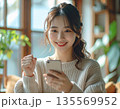スマホを見て喜ぶ日本人女性のポートレート：LPファーストビューやSNS広告に最適なガッツポーズの笑顔 135569952