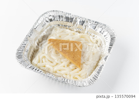 白背景に四角いアルミ容器の中に入った袋入りのうどんと油揚げ（きつねうどん） 135570094
