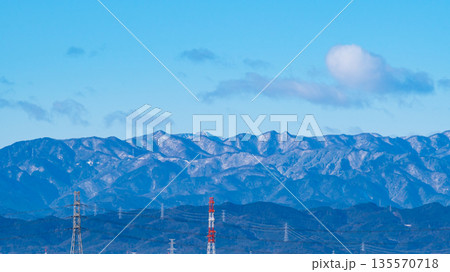 雪化粧した山並みと送電鉄塔が並ぶ眺望　c-1 135570718