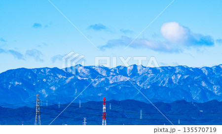雪化粧した山並みと送電鉄塔が並ぶ眺望　c-2 高彩度コントラスト 135570719