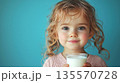 Kid girl holding glass of milk 135570728